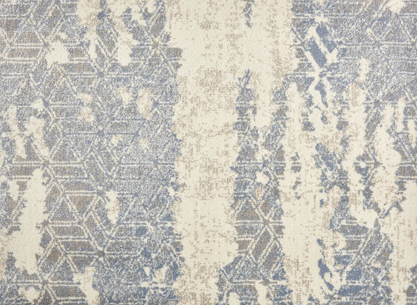 The Delphi On Trend Carpet in Sky features an abstract pattern with faded blue and beige geometric shapes on a textured cream background, evoking elegant flooring with the look of a weathered, distressed rug.