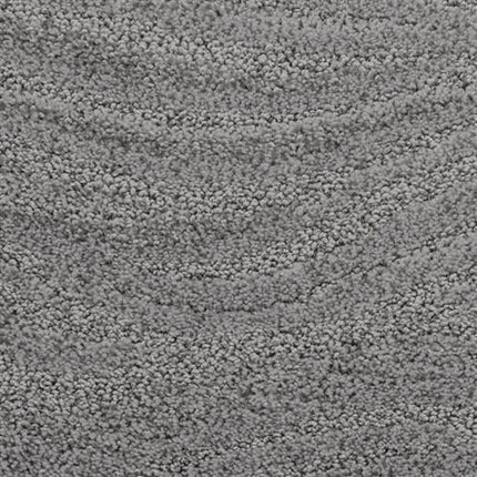 Close-up of Taittinger On Trend Carpet in Smokestack, featuring a soft, looped pile with subtle curved patterns for a textured gray look—durable flooring that's ideal for high-traffic areas.