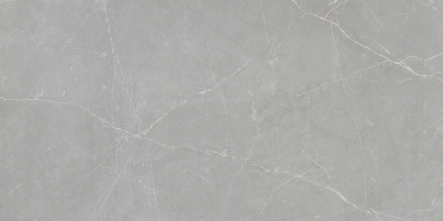 The Callie 12x24 Polished Porcelain Tile in Moonlight features a light gray surface with subtle white veining for a natural stone look and a smooth, luxurious finish.