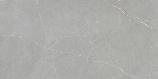 The Callie 12x24 Polished Porcelain Tile in Moonlight features a light gray surface with subtle white veining for a natural stone look and a smooth, luxurious finish.