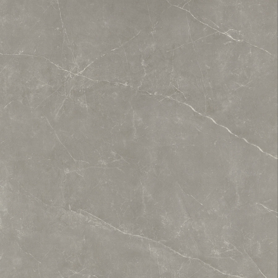 A close-up of the Callie 24x24 Polished Porcelain Tile in Fog shows a smooth gray marble look with subtle white veins and natural diagonal patterns, highlighting the refined elegance of this luxury ceramic tile.