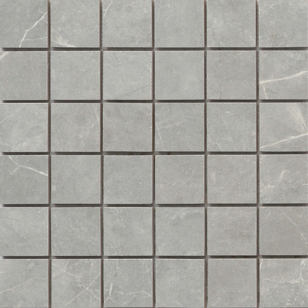 The Callie 2x2 Porcelain Mosaic in Moonlight features square tiles arranged in a precise grid, showcasing a gray marble look with delicate white veining for an elegant, evenly spaced pattern.