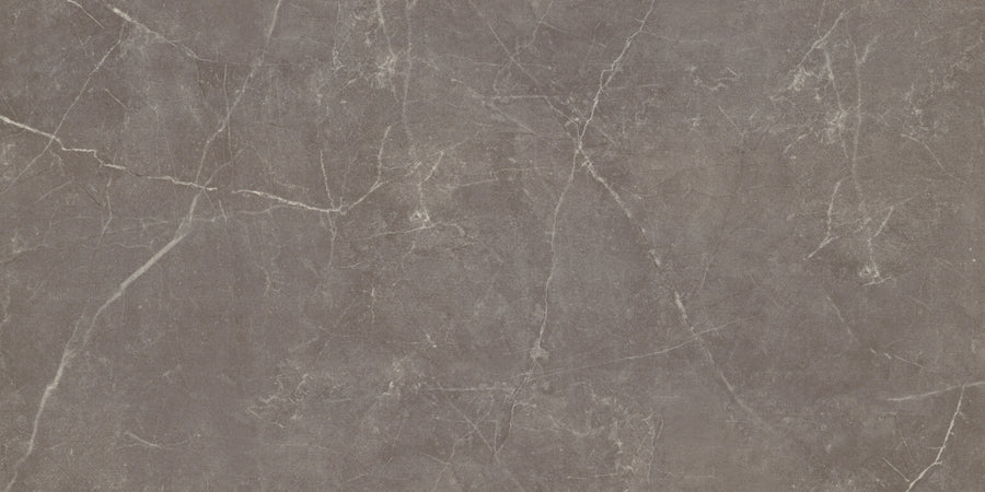 The Callie 12x24 Matte Porcelain Tile in Mocha features a smooth finish with subtle shade variations and natural, textured stone-like patterns, highlighted by thin white veins for an elegant, organic look.