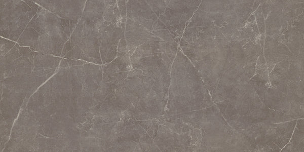 The Callie 12x24 Matte Porcelain Tile in Mocha features a smooth finish with subtle shade variations and natural, textured stone-like patterns, highlighted by thin white veins for an elegant, organic look.