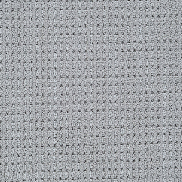 Close-up of Top Notch Berber Carpet in Stone, featuring a textured, grid-like weave with rectangular and square tufts for a soft, stylish surface that’s both premium and stain resistant.