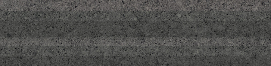 A close-up of Stripes 3" x 12" Subway Tile in Graphite Matte, showcasing a speckled dark gray surface with slightly uneven horizontal light and dark stripes, reminiscent of ceramic tile patterns.