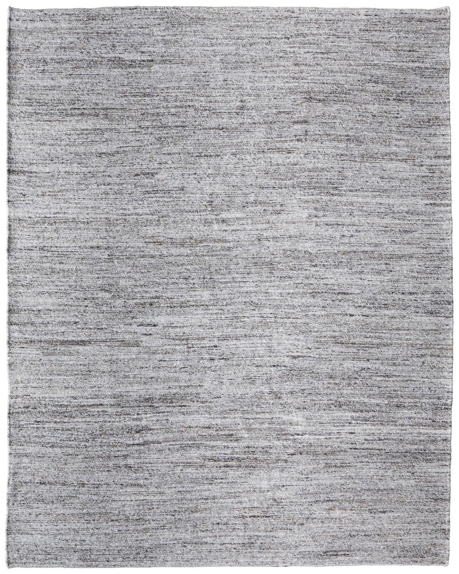 The Finley Area Rug is a large rectangular rug with a subtle textured pattern in light gray. Its minimalist design and finished edges make it an ideal accent for any home décor.