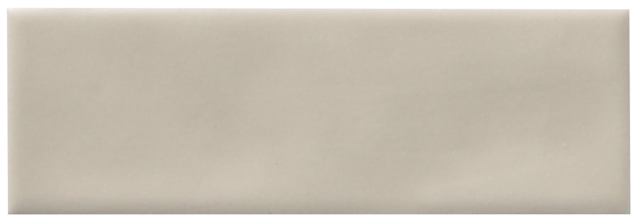 The Zephyr 2x6 Ceramic Tile features a light beige, glossy finish with smooth, slightly rounded edges, adding a touch of Mediterranean-inspired handcrafted luxury to any space.