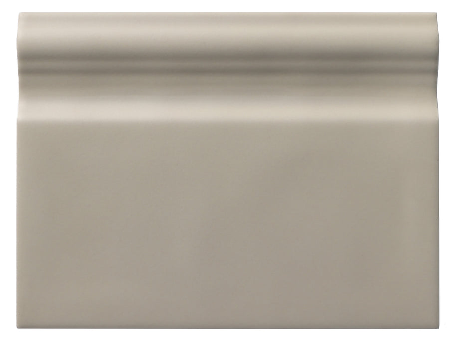 The Zephyr 6x8 Ceramic Baseboard is a rectangular, glossy light gray tile inspired by Mediterranean designs. It features a decorative raised top edge, smooth finish, slight shine, and a subtle curve along the upper border.