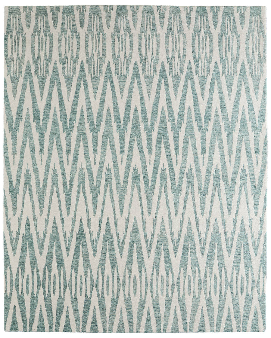 The Wallace 8A40F Area Rug showcases teal and off-white geometric zigzag and diamond patterns, bringing a modern, tribal-inspired elegance to any room.