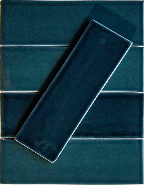 Four Teal Me More Noir Crackle 2.5x8 ceramic tiles are arranged horizontally, with one matching hand-dipped tile placed diagonally on top.