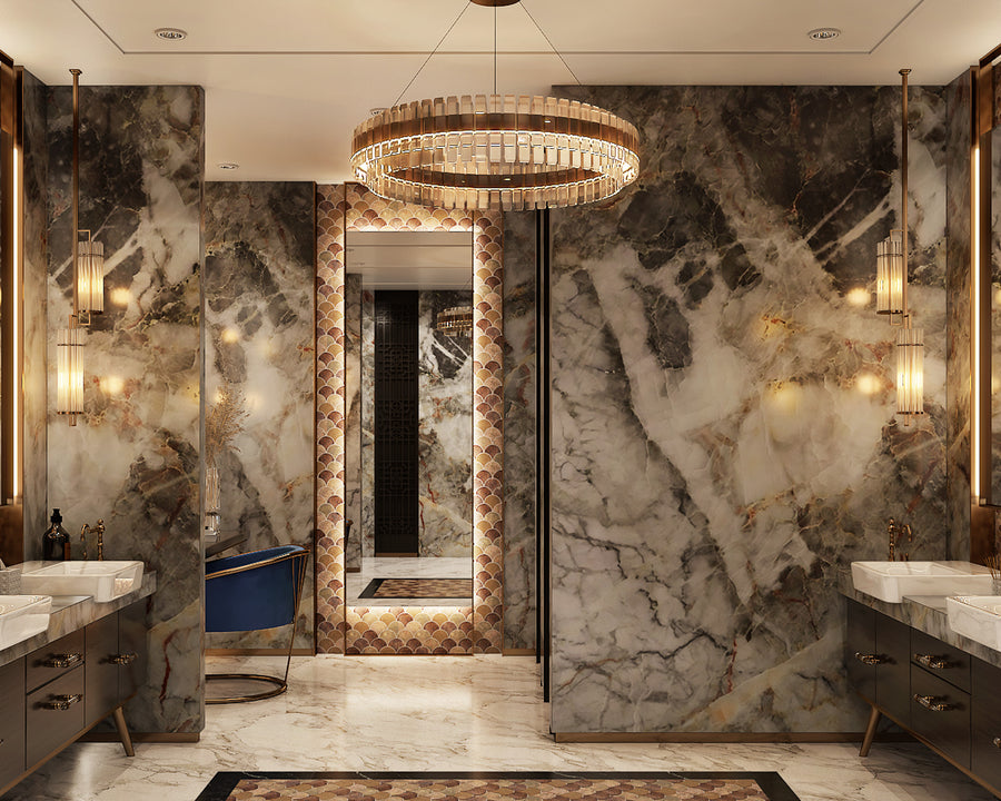 A luxurious bathroom with marble walls and floors, a large round chandelier, double sinks on each side, elegant wall sconces, and a blue chair near a mirrored doorway framed by decorative tiles.