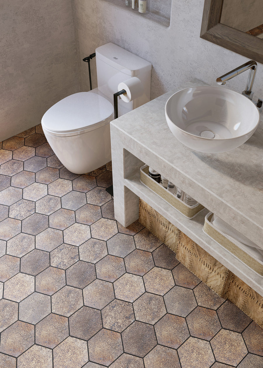 Modern bathroom with a white wall-mounted toilet, a countertop sink, and a stone counter. The floor features large brown hexagonal tiles, and shelves under the counter hold baskets and towels.