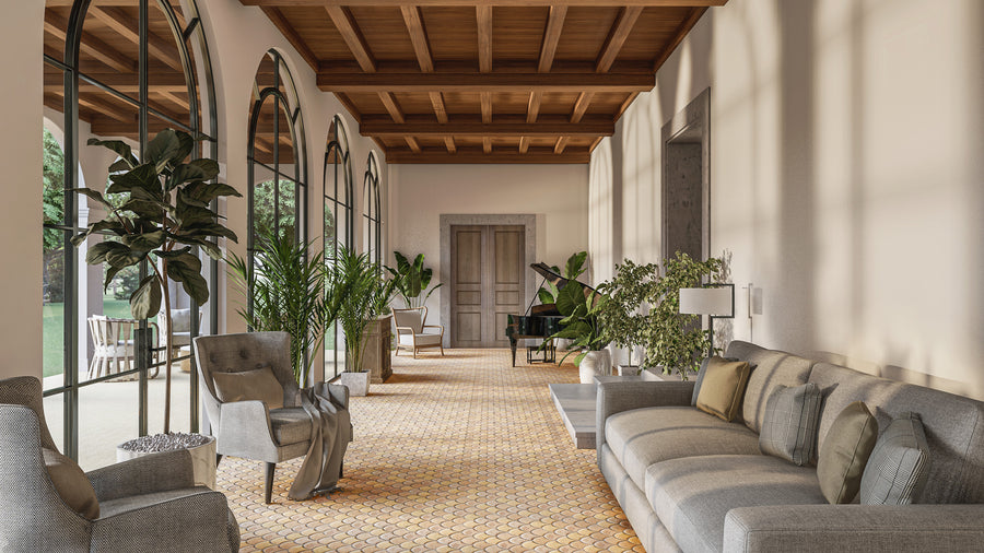A bright, elegant room with arched windows, wooden ceiling, gray sofas and armchairs, indoor plants, lamps, and a grand piano near double doors at the far end. Sunlight streams in, creating a cozy and inviting atmosphere.
