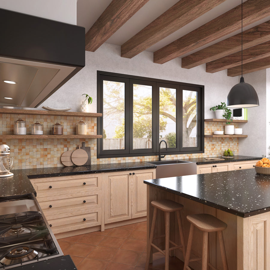 Modern kitchen with wooden cabinets, black countertops, an island with two stools, open shelves with jars, a large window, pendant light, exposed wooden ceiling beams, and mosaic tile backsplash.