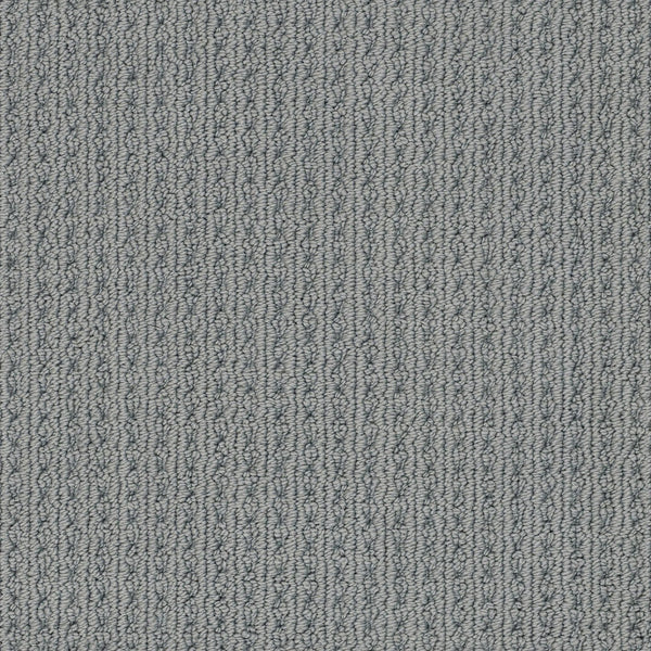 Close-up of San Lucas Family Friendly Carpet in Tin, featuring a textured, looped pattern with vertical ridges and subtle gray variations—perfect for high-traffic homes needing comfort and durability.
