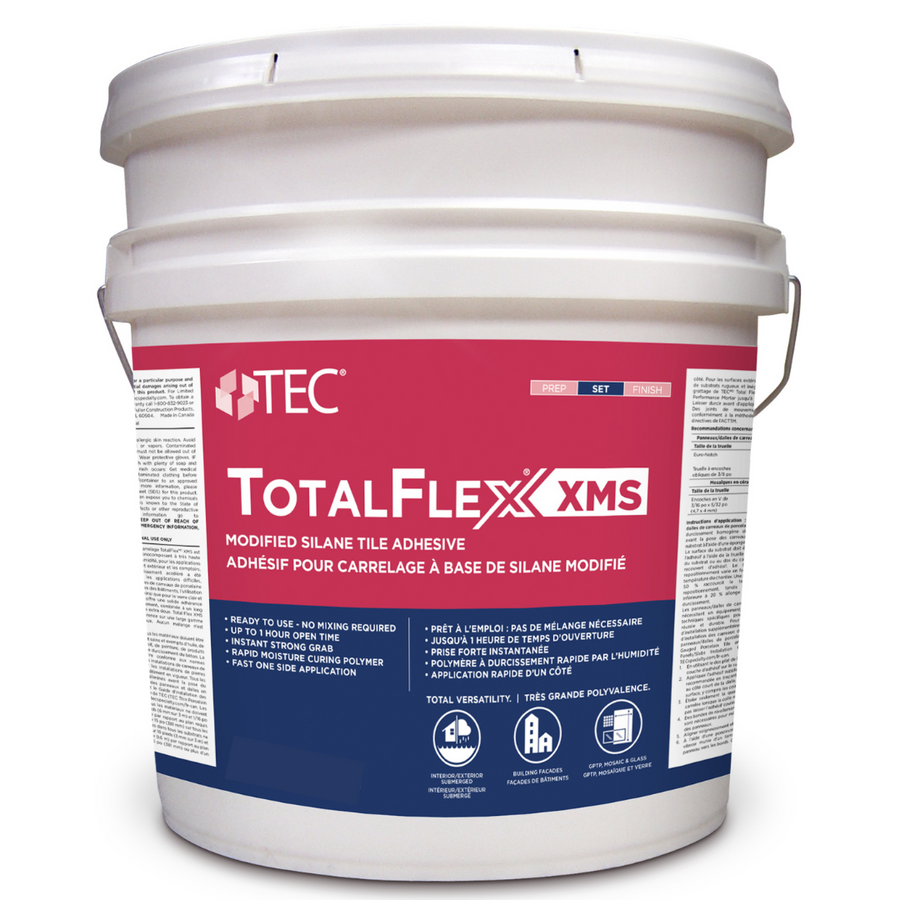 A large white plastic bucket labeled TotalFlex® XMS Tile Adhesive by TEC, with info on exterior wall use and modified silane formula in English and French, plus red, blue, and white text and graphics on the front.