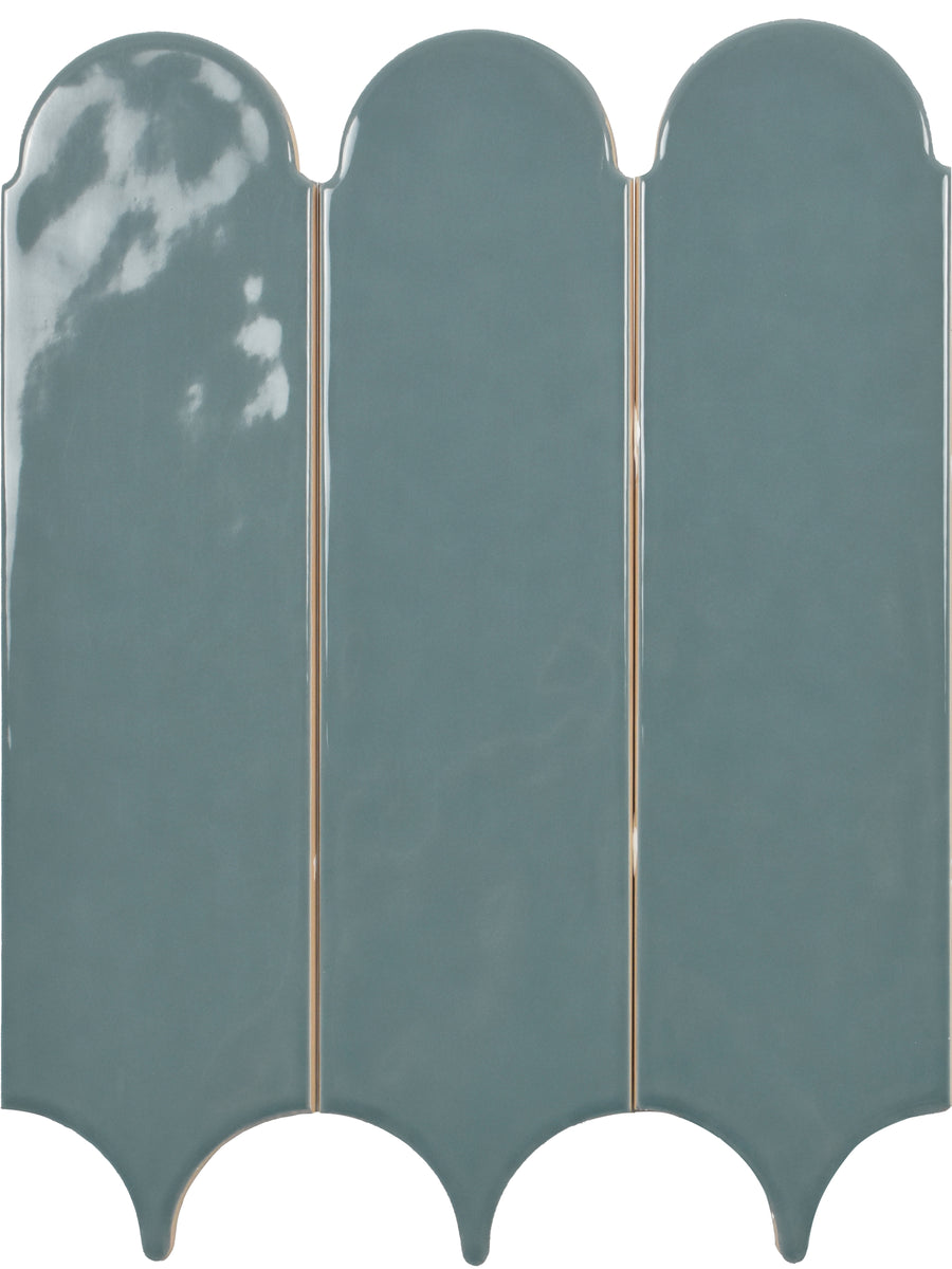 Three Tranquill 3x12 glazed ceramic tiles with a glossy teal finish and scalloped edges are aligned vertically against a white background, creating a timeless look.
