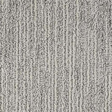Close-up of Advocate Berber Carpet in Trophy, featuring a light gray looped pile with subtle vertical and horizontal lines that form a linear pattern.