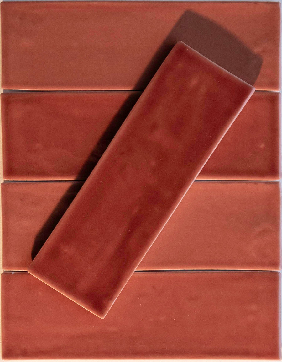 Five Noir Crackle 2.5x8 Ceramic Tiles in Tuscadero are arranged horizontally in a grid, with one matching tile placed diagonally on top, casting a shadow.
