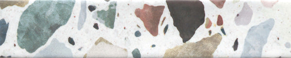 The Fragmento 2x10 Ceramic Tile in Tutti Frutti features a terrazzo-look with bold, irregular stone fragments in green, brown, gold, gray, pink, and black embedded on a white background.