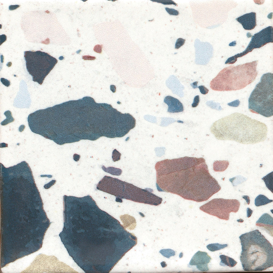 The Fragmento 5x5 Ceramic Tile in Tutti Frutti features a bold terrazzo look with a white background and scattered chips in blue, black, pink, brown, and green.