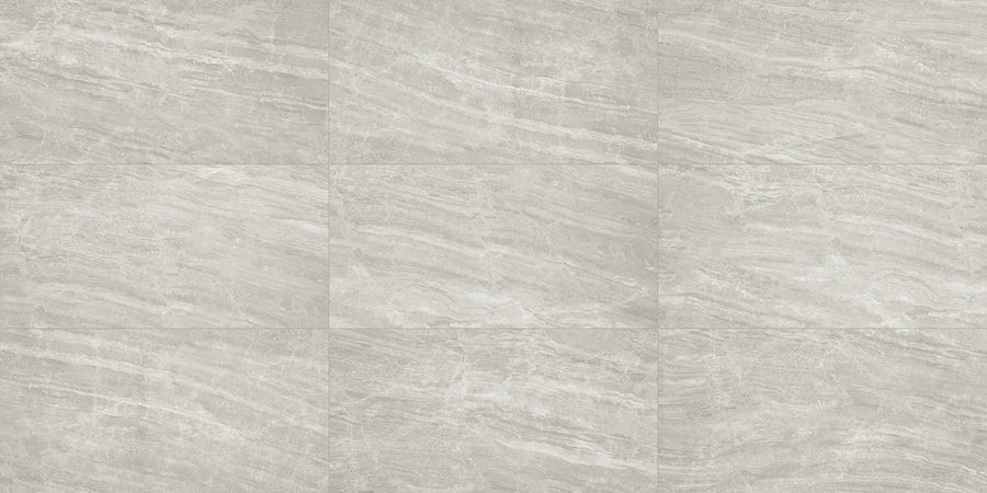 The Cosmic 12x24 Rectified Porcelain Tile features a light gray, marble-like pattern with horizontal veins and smooth, precise edges, delivering a natural stone look in a modern grid arrangement.