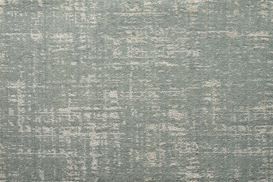 A close-up of the Velvet Abstract On Trend Carpet in blue highlights its plush texture and subtle distressed pattern, blending light and dark areas for a modern abstract look.