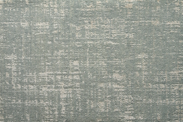 A close-up of the Velvet Abstract On Trend Carpet in blue highlights its plush texture and subtle distressed pattern, blending light and dark areas for a modern abstract look.