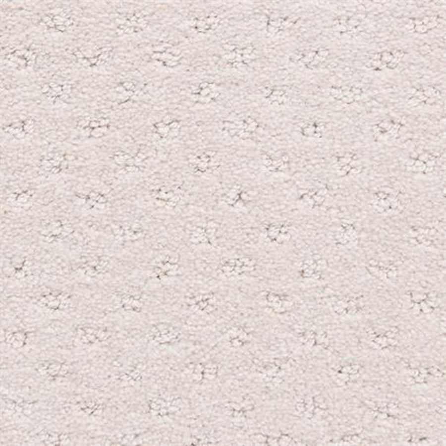 Close-up of Dreamer On Trend Carpet in Vanilla shows its light beige, durable surface with a repeating small dot pattern. Soft, plush fibers create a subtle raised texture for a luxurious and uniform flooring look.