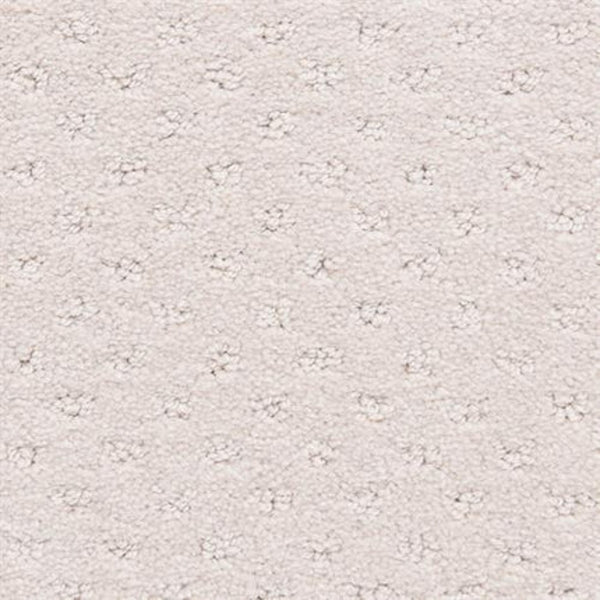 Close-up of Dreamer On Trend Carpet in Vanilla shows its light beige, durable surface with a repeating small dot pattern. Soft, plush fibers create a subtle raised texture for a luxurious and uniform flooring look.