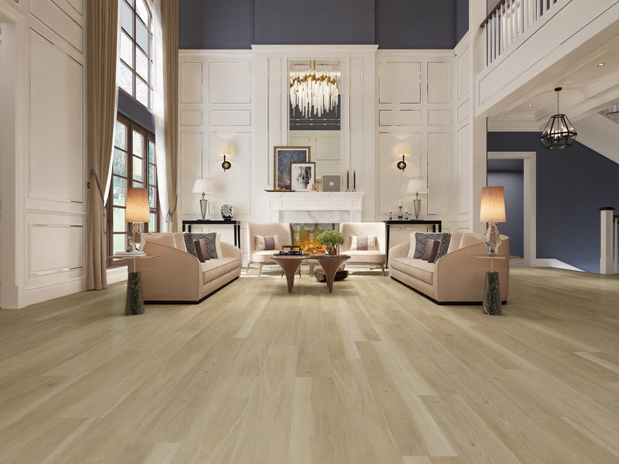 A spacious, elegant living room with tall white walls, large windows, two beige sofas facing each other, a wooden coffee table, lamps, a modern chandelier, and realistic hardwood look using Hydro Vinyl 7" Waterproof Vinyl Plank flooring.