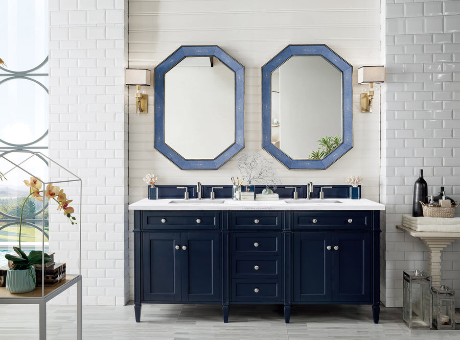 A modern bathroom features the Brittany 72" Double Bowl Vanity in navy blue, two octagonal blue-framed mirrors, wall sconces, white subway tile walls, and decorative accents on the countertop.