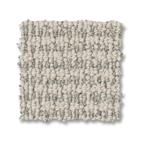 A square swatch of Laine On Trend Carpet shown in a loop-pile design with light beige and gray tones, displayed on a white background for a premium look.