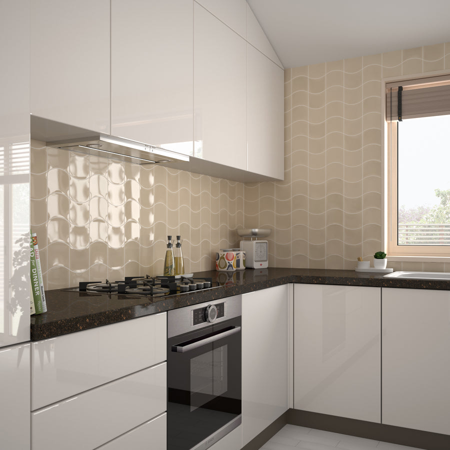 A modern kitchen with glossy white cabinets, a black countertop, a built-in oven, a gas stove, and beige wavy-patterned wall tiles. Appliances and decor items sit on the counters near a window with blinds.