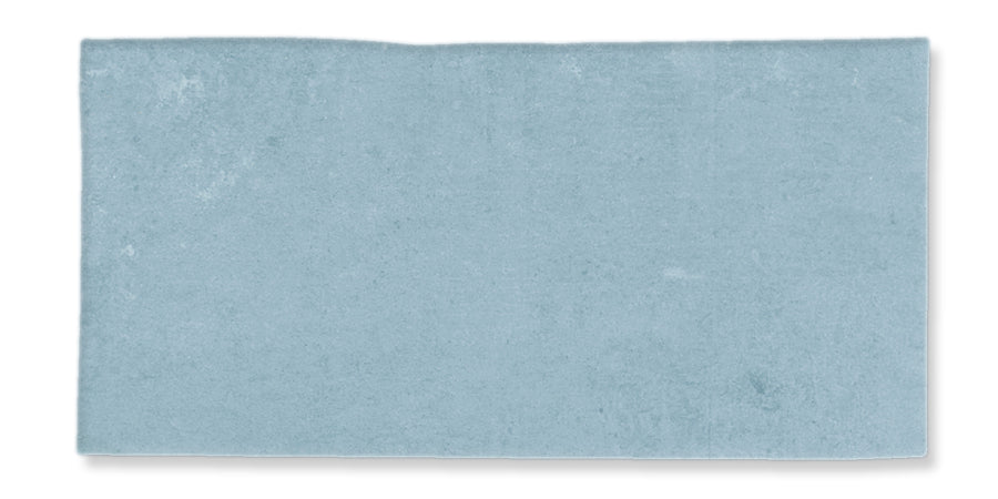 A rectangular, light blue rug or mat with a slight uneven edge on the top side, photographed against a white background.