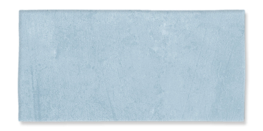 A rectangular tile with a smooth, matte light blue surface and subtle texture variation.