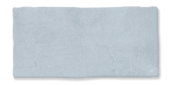 A rectangular, light gray tile with a slightly uneven, textured surface and rough edges, set against a white background.