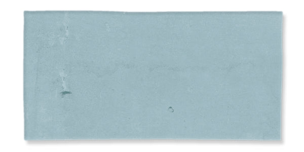 A rectangular, light blue tile with a slightly uneven surface texture and subtle variations in color.
