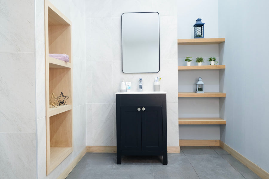 A modern bathroom features the Aria 24" Vanity, a rectangular mirror, open shelves with plants and decor, a built-in wooden towel nook, and sleek gray tile flooring for transitional style.