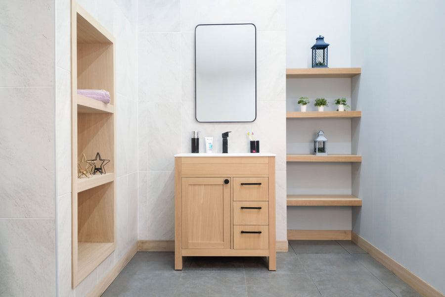 Modern bathroom featuring the Aria 30" Vanity, a rectangular mirror, open shelves with potted plants and decor, plus built-in shelving for towels. Light walls enhance this clean, minimalist luxury vanity space.