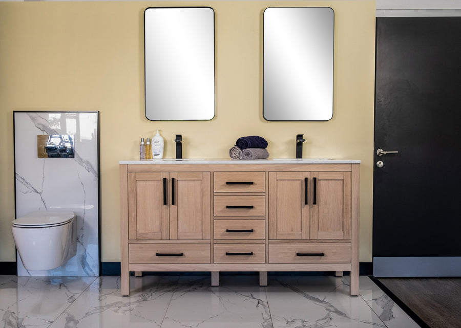 Modern bathroom with the Ashley 60" Double Bowl Vanity in natural oak, two rectangular mirrors, black faucets, folded towels, and toiletries. A wall-mounted toilet is on the left against a yellow wall with marble tile flooring.