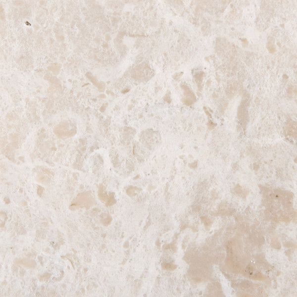 Close-up of the Quad Shower Shelf’s light beige stone surface, showcasing a rough, uneven texture with natural patterns, small holes, and subtle color variations—perfect for a stylish bathroom shelf.