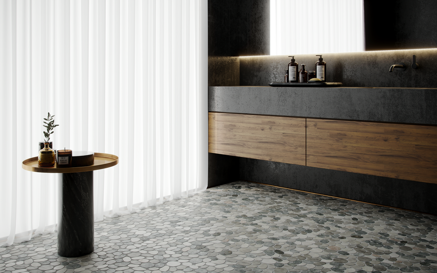 Modern bathroom with dark walls, a floating wooden vanity, round stone tile floor, and a small marble table with decor. Soft natural light filters through sheer white curtains.