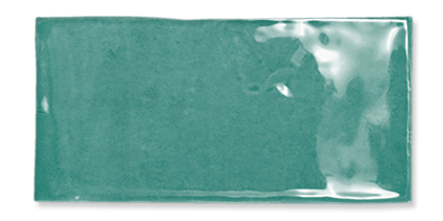 A rectangular teal ceramic tile with a glossy, uneven surface and slightly wavy edges, set against a white background.