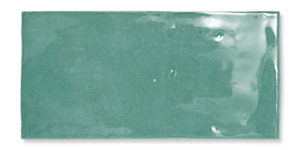 Glossy rectangular ceramic tile in a muted green color, shown against a white background. The tile surface has a smooth, slightly reflective finish with subtle texture and minor imperfections.