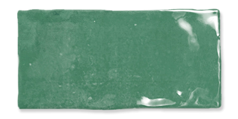 A rectangular, glossy green ceramic tile with slightly uneven edges and a reflective surface.