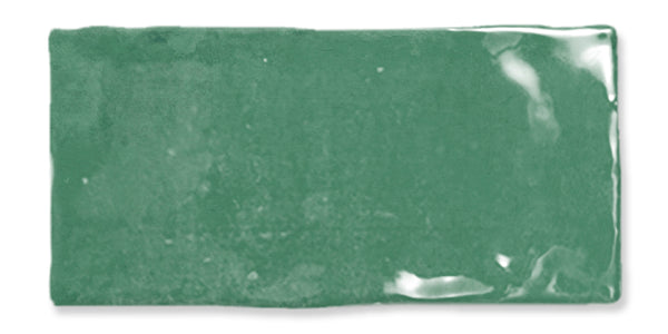 A rectangular, glossy green ceramic tile with slightly uneven edges and a reflective surface.