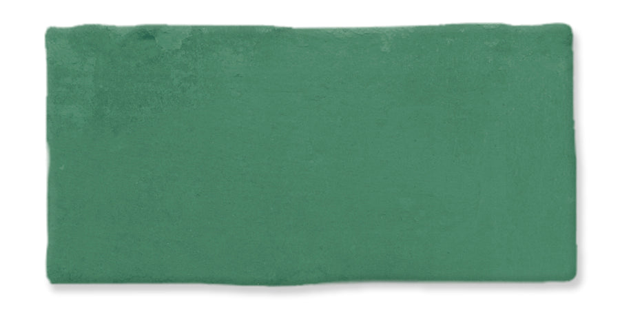 A rectangular slab of matte, green modeling clay is shown against a white background. The edges are slightly uneven, and the surface appears smooth with faint texture.