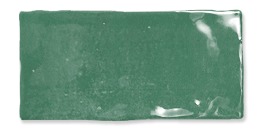 A rectangular, glossy green ceramic tile with slightly uneven edges and a smooth, reflective surface.